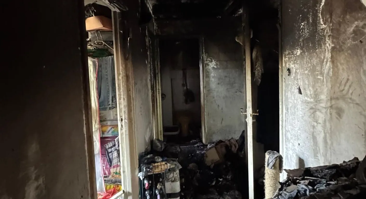 Doorgang in een woning na een brand met zwartgeblakerde wanden, kozijnen en deuren