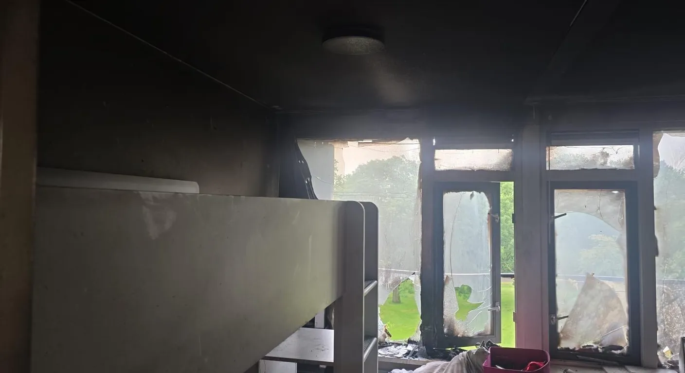 Uitgebrande kamer met een zwart plafond en gesmolten ramen, de dag na de brand